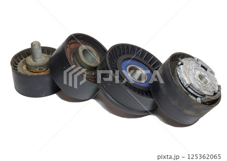 tensioner, idlers, pulleys of car actuators of engine and alternator. dismantled worn rollers of car drive mechanisms. stacked in line, on white background 125362065