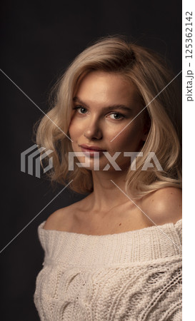 Studio photo portrait of a young pretty blonde on a dark background, close-up portrait of a woman 125362142