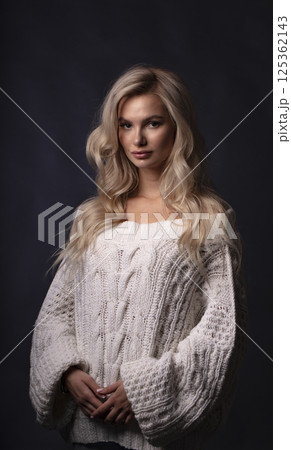 Studio photo portrait of a young pretty blonde on a dark background, close-up portrait of a woman 125362143