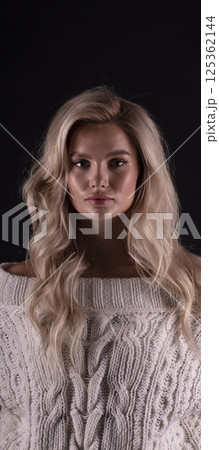 Studio photo portrait of a young pretty blonde on a dark background, close-up portrait of a woman 125362144