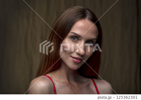 studio portrait on a dark background of a beautiful young woman 125362301