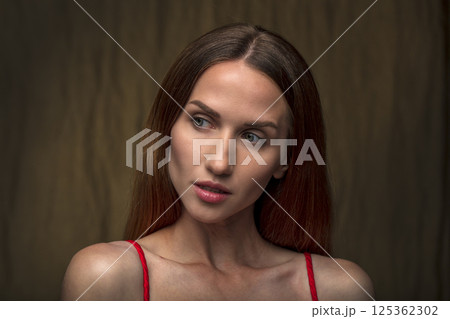 studio portrait on a dark background of a beautiful young woman 125362302
