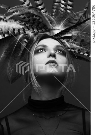 Woman with feather headpiece studio portrait Woman with feather headpiece studio portrait 125364706