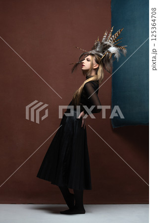 Woman with feather headpiece studio portrait 125364708