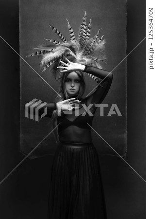 Woman with feather headpiece studio portrait 125364709