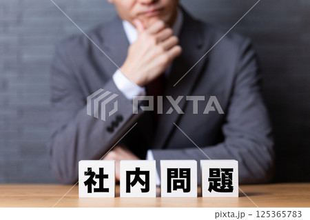 社内問題のブロックとスーツを着て悩むミドル男性ビジネスマン 社内問題のブロックとスーツを着て悩むミドル男性ビジネスマン 125365783