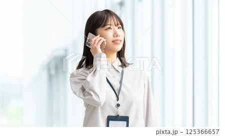 スマートフォンで話す笑顔の女性・ビジネスウーマン 125366657