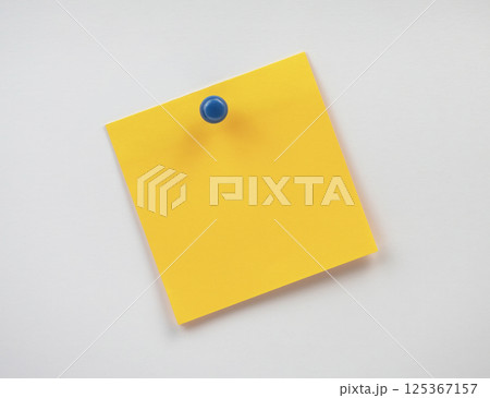A yellow sticky note is attached to a wall, ready for reminders or notes A yellow sticky note is attached to a wall, ready for reminders or notes 125367157