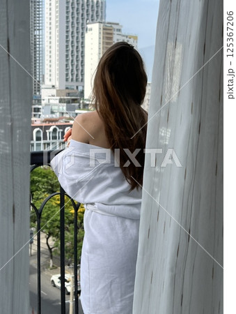 A elegant luxury woman with a white enjoys the view over the Downtown City  125367206