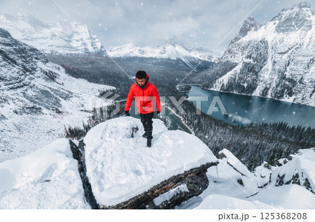Asian male tourist standing on Opabin Plateau with snowy Rocky Mountains and Lake Ohara in Yoho national park at Canada Asian male tourist standing on Opabin Plateau with snowy Rocky Mountains and Lake Ohara in Yoho national park at Canada 125368208