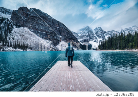 Traveler man walking on pier surrounded by Rocky mountains on Moraine Lake at Banff national park, canada 125368209