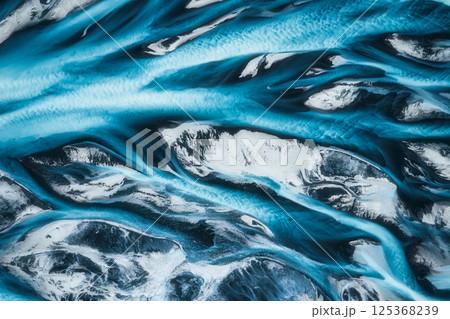 Abstract blue glacier river delta flowing through rugged landscape in Icelandic Highlands 125368239