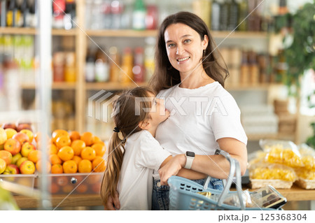 Teenage girl and mother choose different products together in grocery supermarket Teenage girl and mother choose different products together in grocery supermarket 125368304