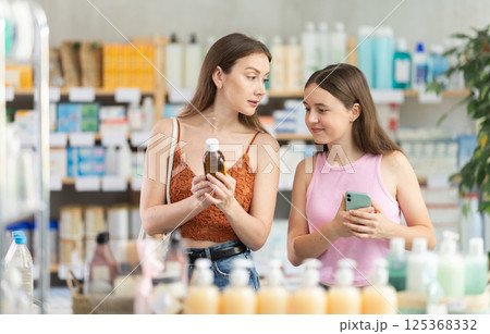 woman with a child chooses cough syrup woman with a child chooses cough syrup 125368332