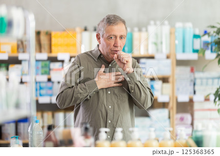 Senior man visits pharmacy and suffers from cough 125368365