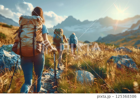 A group friends hiking with large backpacks to along mountain path through. Friends hike through the stunning landscape, their large backpacks ready for the adventure they seek. 125368386