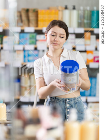 Woman buys food for small children in supermarket Woman buys food for small children in supermarket 125368457