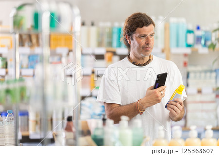 Adult man scanning qr code of repellent 125368607