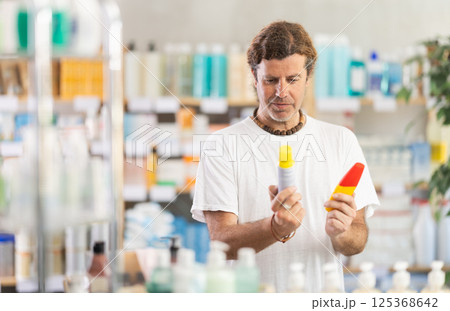man chooses a repellent at the pharmacy man chooses a repellent at the pharmacy 125368642