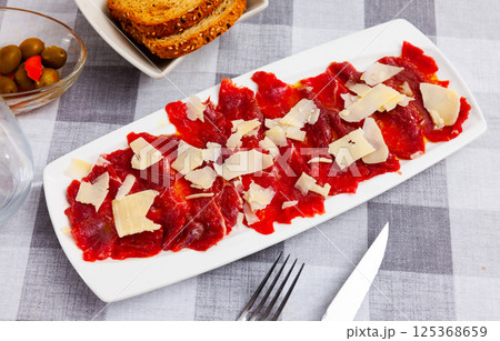 Beef carpaccio cold appetizer with parmesan, on plate Beef carpaccio cold appetizer with parmesan, on plate 125368659