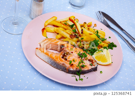 Tasty grilled salmon served with french fries Tasty grilled salmon served with french fries 125368741