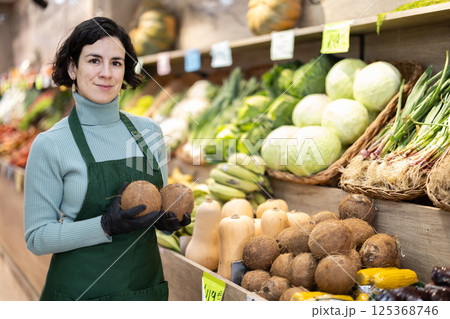 Adult woman seller puts coconuts on display 125368746