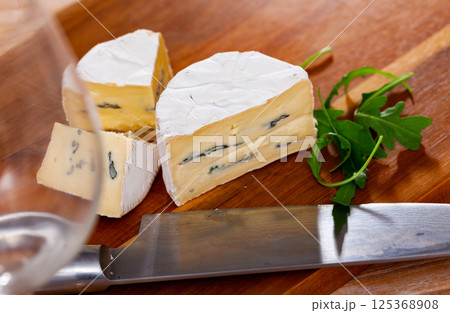 Slices of soft blue cheese on cutting board 125368908