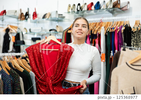 Young woman choosing dress in store 125368977