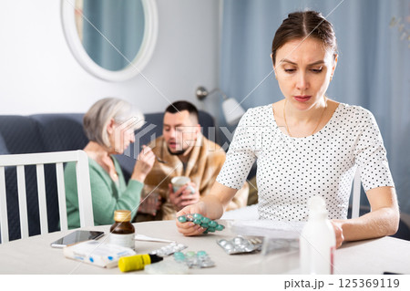 Woman thinking about treatment for her ill husband at home Woman thinking about treatment for her ill husband at home 125369119