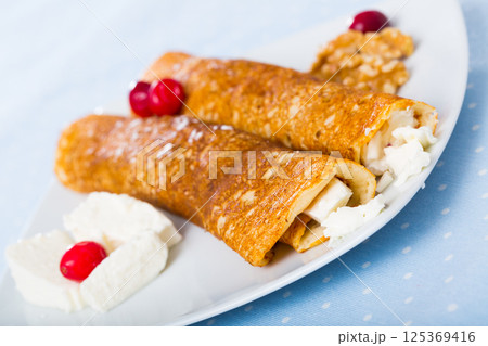 Dish of pancakes palachinki with filling from brynza and walnuts Dish of pancakes palachinki with filling from brynza and walnuts 125369416