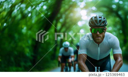 Portrait of a cyclist participating in a race, green alley of a city park, athlete in aerodynamic clothing, helmet and sunglasses, endurance race competition in an accessible urban environment 125369463