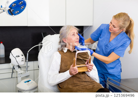 Cosmetologist and senior woman during doctor's appointment Cosmetologist and senior woman during doctor's appointment 125369496