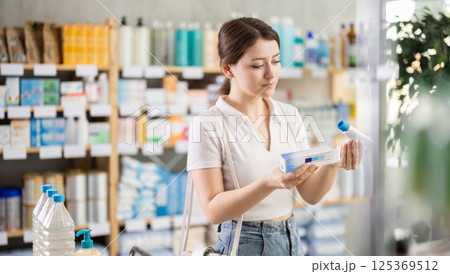 Female customer choosing therapeutic ointment in pharmacy Female customer choosing therapeutic ointment in pharmacy 125369512