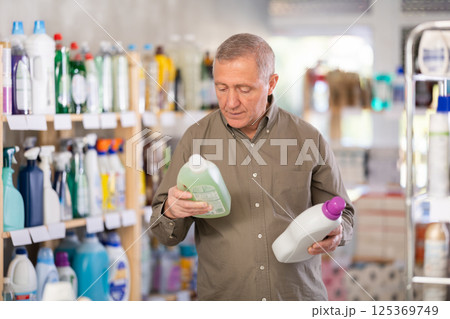 Male consumer with household chemical products for washing indoors Male consumer with household chemical products for washing indoors 125369749