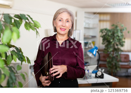Businesswoman with briefcase for documents in office 125369756