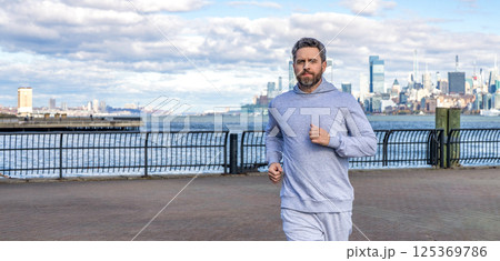 Man sportsman running for exercise in active wear. Sportsman jogger running. Morning sport workout runner running. Sport runner in Manhattan. Sportsman in New York. Copy space banner Man sportsman running for exercise in active wear. Sportsman jogger running. Morning sport workout runner running. Sport runner in Manhattan. Sportsman in New York. Copy space banner 125369786