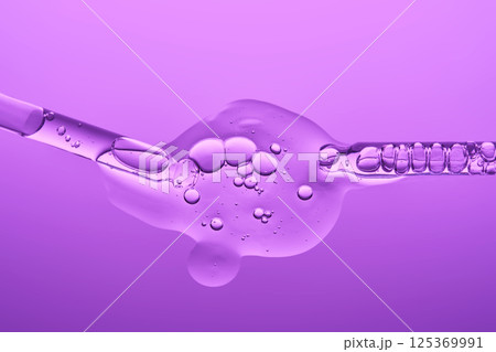 Two pipettes with serum on a lilac background. The texture. 125369991