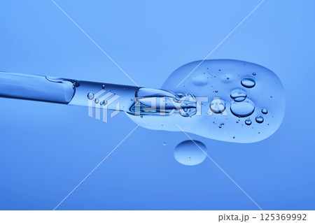 Serum with peptides on a blue background with a pipette. The texture. 125369992