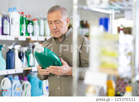 Male consumer with household chemical products for washing indoors Male consumer with household chemical products for washing indoors 125370111