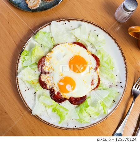Fried egg with chorizo sausage served for breakfast 125370124