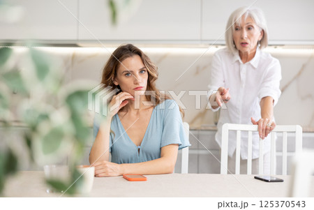 Aggrieved woman having quarrel with her daughter at home. Elderly mother expresses claims to adult daughter 125370543
