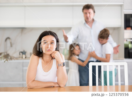 Offended mother sitting at the kitchen table Offended mother sitting at the kitchen table 125370556