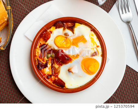 Popular spanish dish is fried eggs with chistorra Popular spanish dish is fried eggs with chistorra 125370594