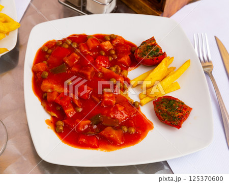 Tilapia fillet with vegetables, french fries and sun-dried tomatoes Tilapia fillet with vegetables, french fries and sun-dried tomatoes 125370600