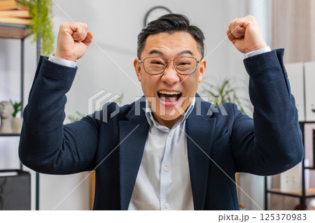 Happy amazed businessman shocked by sudden victory, game winning, lottery goal achievement good news Happy amazed businessman shocked by sudden victory, game winning, lottery goal achievement good news 125370983