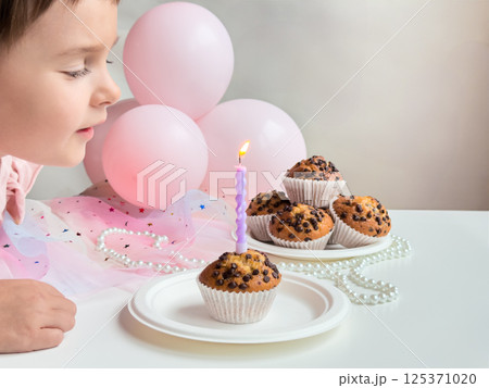 Caucasian child birthday celebration with cupcakes and pink balloons. Birthday concept Caucasian child birthday celebration with cupcakes and pink balloons. Birthday concept 125371020