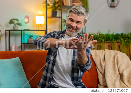 Happy rich mature middle-aged man showing wasting or throwing money around hand gesture more tips 125371067