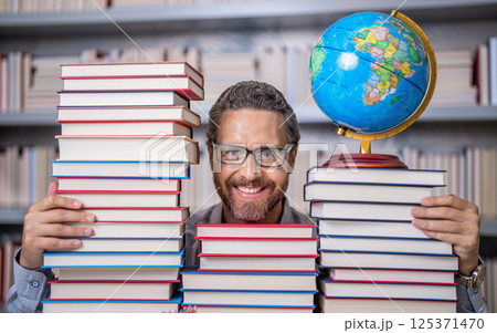 Teachers Day. Tutor at classroom. Man geographer with books in classroom. Knowledge and education concept. school teacher with book in classroom. teacher in classroom. Lost in a good book Teachers Day. Tutor at classroom. Man geographer with books in classroom. Knowledge and education concept. school teacher with book in classroom. teacher in classroom. Lost in a good book 125371470