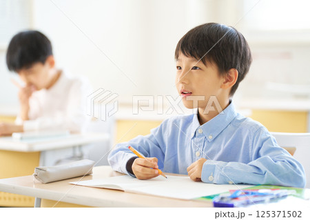 教室で勉強中の男子小学生|背筋を伸ばして前を見る 教室で勉強中の男子小学生|背筋を伸ばして前を見る 125371502