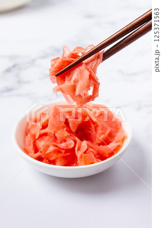 Pickled ginger, with chopsticks, in a small white bowl, on a marble countertop, close-up, no people, Pickled ginger, with chopsticks, in a small white bowl, on a marble countertop, close-up, no people, 125371563